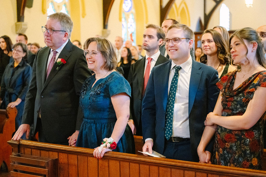 Wedding guests smile during ceremony.